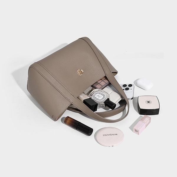 Structured trapezoid tote bag in taupe pebbled leather-look finish with gold-tone turn-lock hardware, dual top handles, and