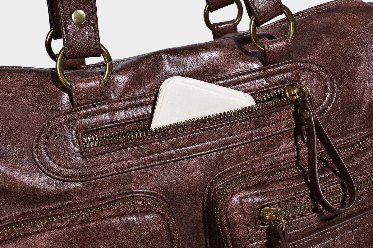Distressed leather-look vintage satchel shoulder bag with multiple front zip pockets, dual top handles, and brass-tone