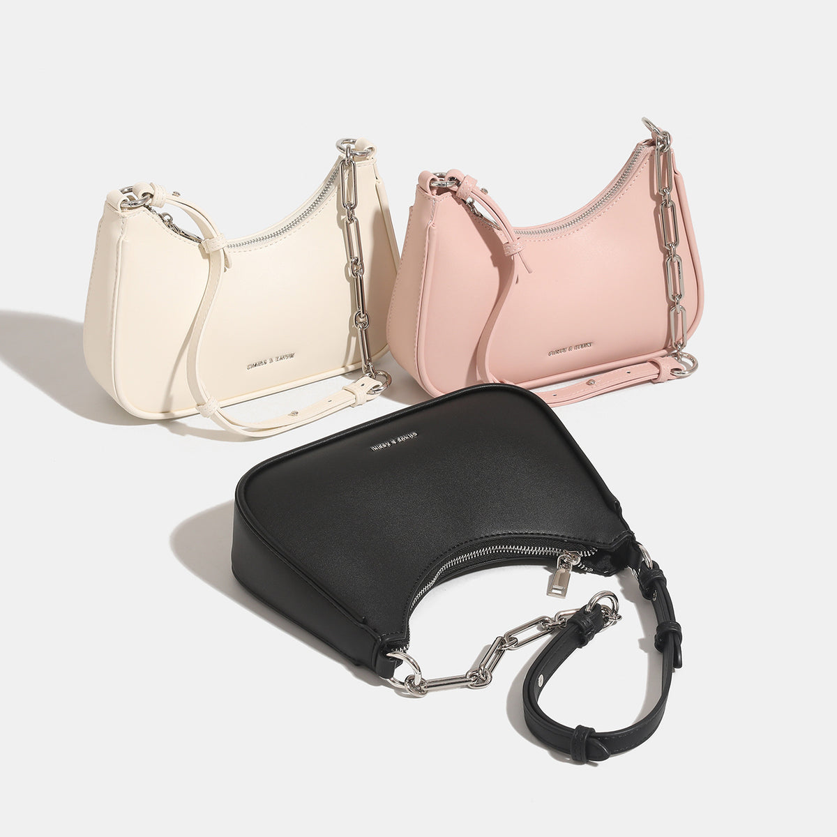 Compact hobo shoulder bag with smooth leather-look finish, top zip closure, and mixed silver chain and adjustable strap