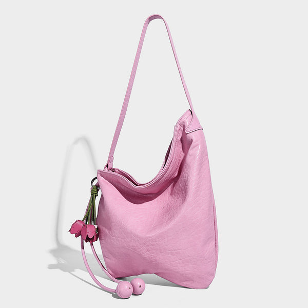 Slouchy hobo shoulder bag in pale yellow with slim strap, drawstring bead closure, and pink tulip floral charm, detail view 8