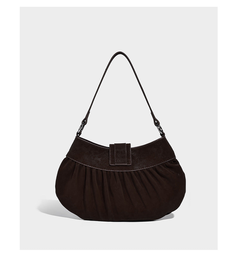 Ruched shoulder bag with curved flap, silver star studs, dangling starfish charm, and adjustable crossbody strap, detail view