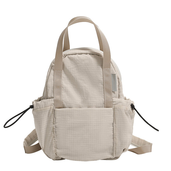 Mini rounded convertible backpack handbag in matte ripstop fabric with dual top handles, adjustable straps, and side, detail