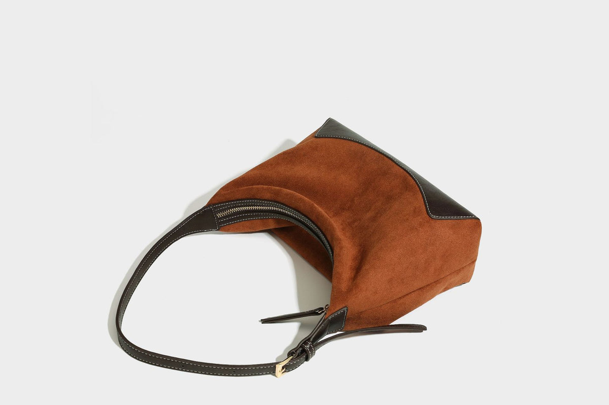 Lässig fallende Hobo-Schultertasche in warmem Braun mit dunkler Kontrastverzierung in Lederoptik, geschwungenem Reißverschluss und langem, detail