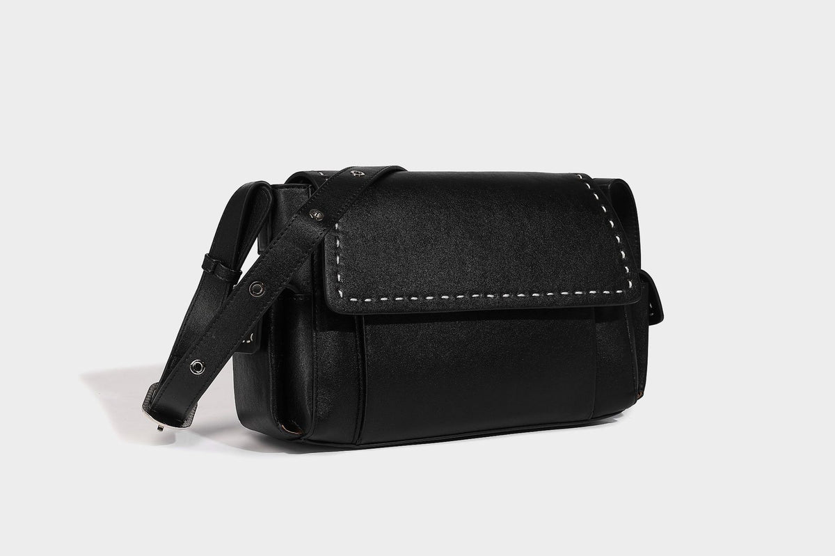 Structured flap crossbody bag in dark brown and cream color-block with white contrast stitching, adjustable shoulder strap