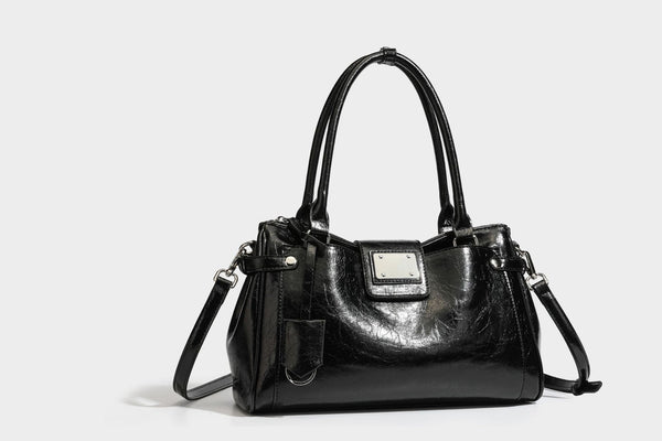 Structured glossy crinkled leather-look satchel with double top handles, front metal-plaque tab, silver-tone hardware, and