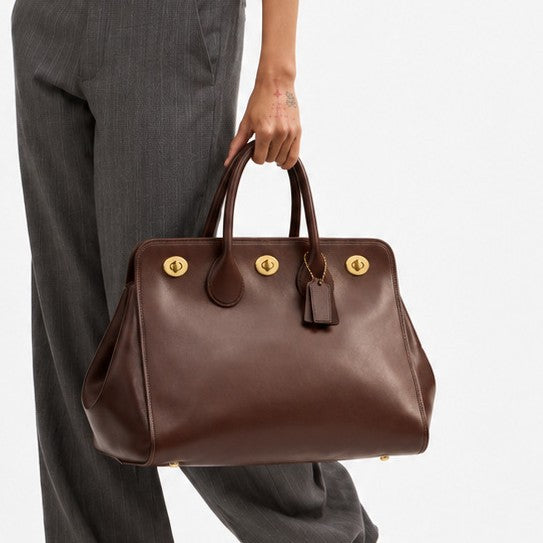 Structured leather-look tote bag with three gold-tone turn-lock closures and double rolled top handles, detail view 2