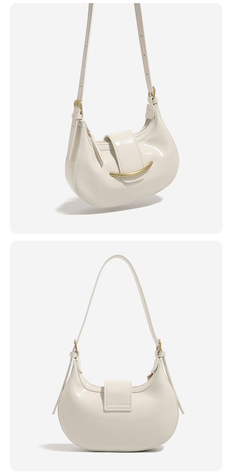 Compact crescent hobo shoulder bag with glossy synthetic finish, curved gold-tone front bar hardware, zip-top closure, and