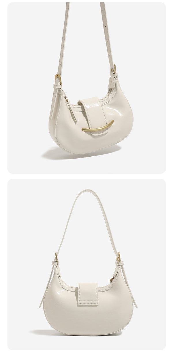 Compact crescent hobo shoulder bag with glossy synthetic finish, curved gold-tone front bar hardware, zip-top closure, and