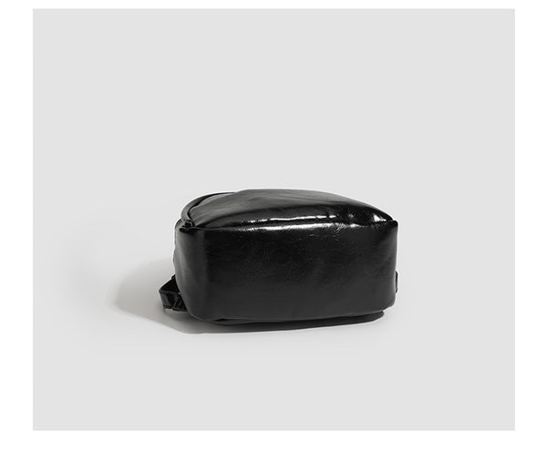 Kompakte, abgerundete Mini-Rucksackhandtasche mit glänzender Lederoptik, Reißverschluss oben, Fronttasche, Tragegriff oben und Detailansicht
