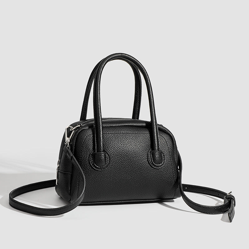 Mini-Boston-Tasche mit genarbter Oberfläche, zwei Tragegriffen, abnehmbarem verstellbarem Crossbody-Riemen und Beschlägen in Silberoptik, Detailansicht
