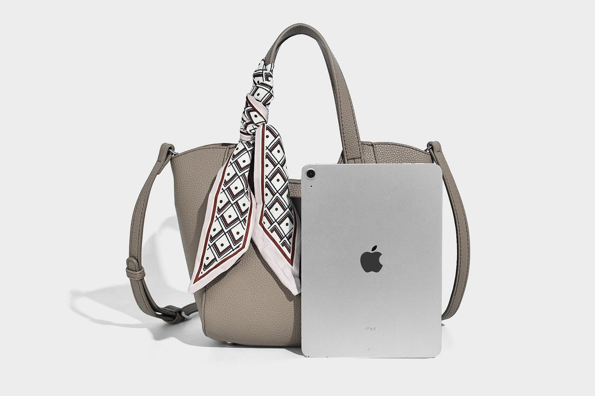 Structured pebbled leather-look tote bag with detachable scarf tie, dual top handles, and adjustable crossbody strap, detail
