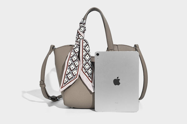 Structured pebbled leather-look tote bag with detachable scarf tie, dual top handles, and adjustable crossbody strap, detail