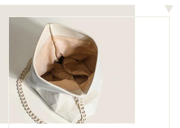 Cream white rectangular flap shoulder bag with geometric faceted surface and chunky tone-on-tone chain strap with gold-tone