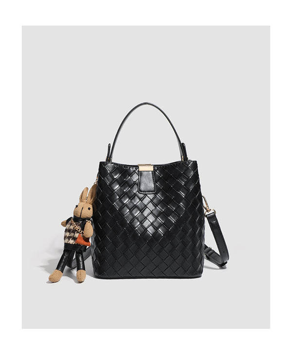 Black woven leather-look bucket bag with gold-tone clip closure, top handle, detachable shoulder strap, and knit bunny charm
