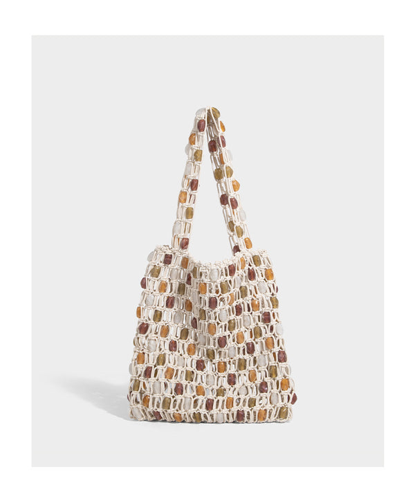 Cream macramé open-weave tote bag with multicolor amber olive and translucent bead accents and woven shoulder straps, detail
