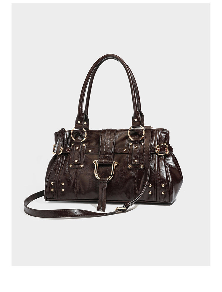 Dark brown glossy leather-look structured satchel tote with gold-tone studs, buckle straps, dual top handles, and detachable
