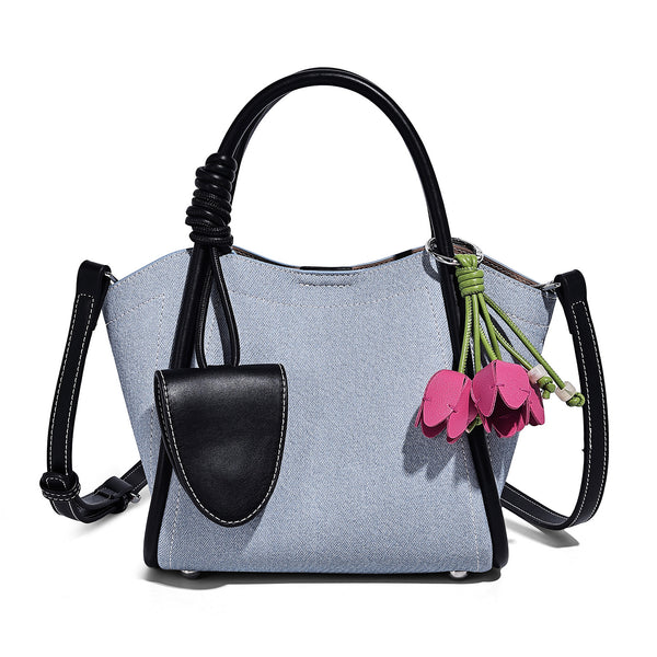Structured canvas tote bag with knotted top handles, leather-look black trim, front flap pocket, and pink tulip flower charm