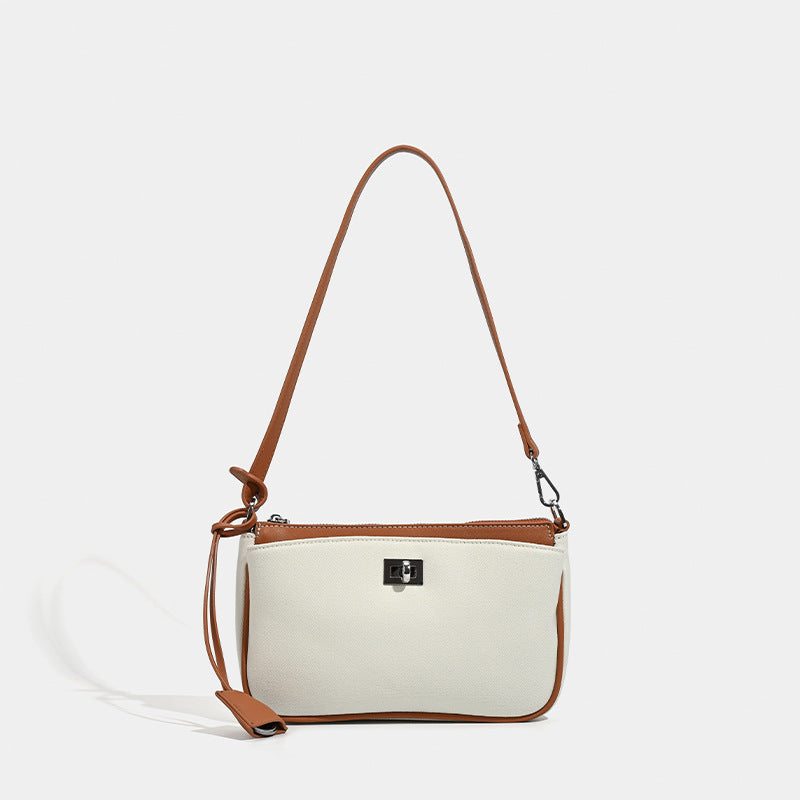 Small structured cream crossbody bag with contrast leather-look trim, silver-tone turn-lock hardware, and adjustable