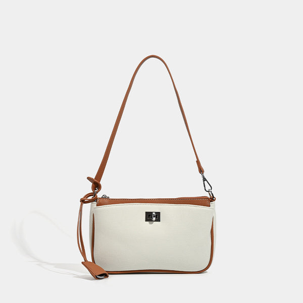 Small structured cream crossbody bag with contrast leather-look trim, silver-tone turn-lock hardware, and adjustable