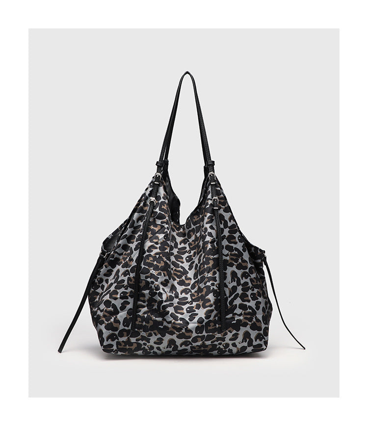 Large leopard-print slouchy tote shoulder bag in grey, black, and tan with gold-tone hardware and adjustable leather-look