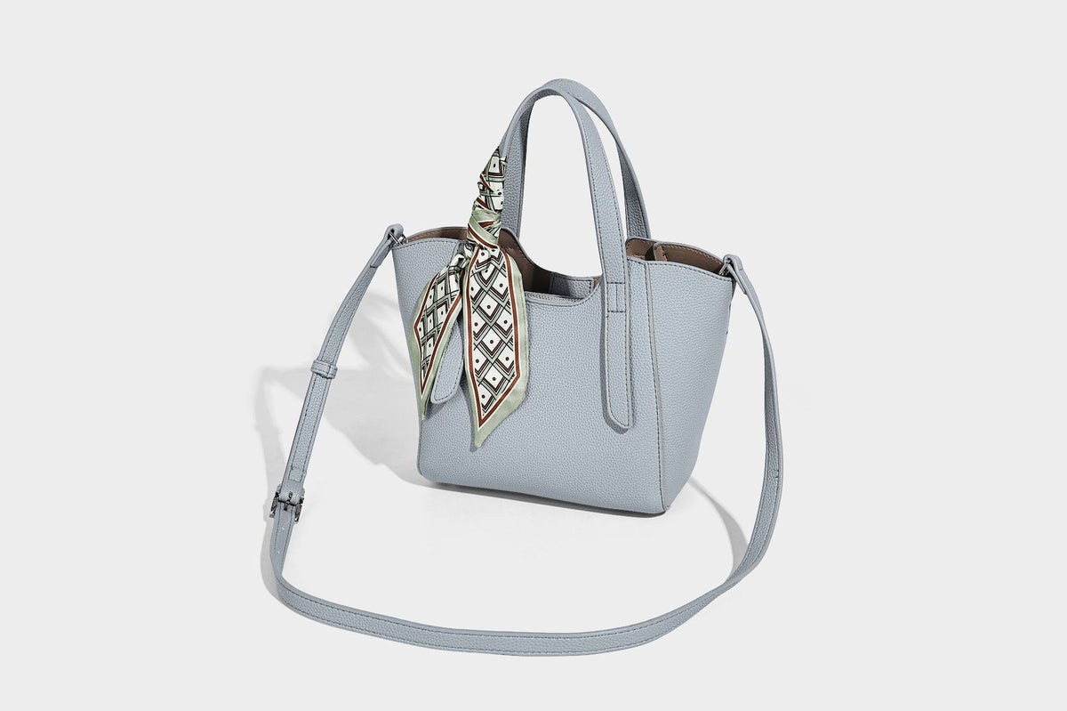 Structured pebbled leather-look tote bag with detachable scarf tie, dual top handles, and adjustable crossbody strap, detail