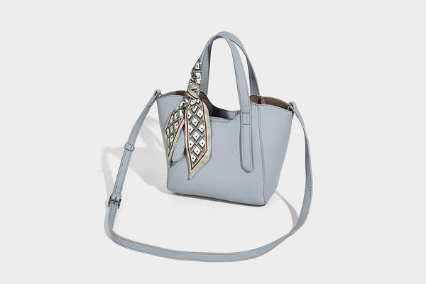 Structured pebbled leather-look tote bag with detachable scarf tie, dual top handles, and adjustable crossbody strap, detail
