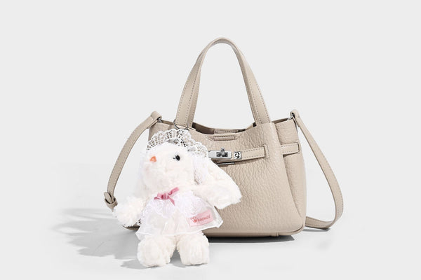 Small structured pebbled bucket tote with double top handles, silver turn-lock hardware, and detachable shoulder strap