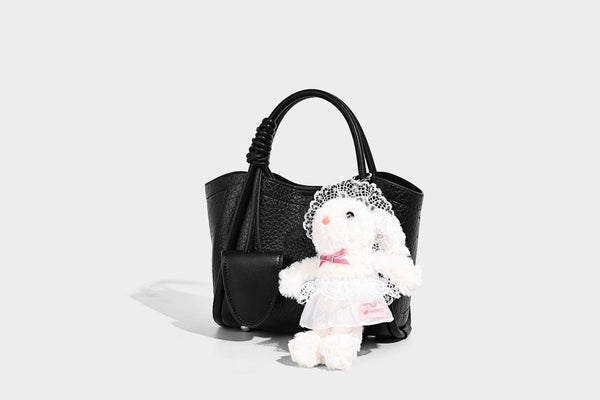 Structured mini tote bag in pebbled leather-look finish with knotted top handles, front flap pocket, and detachable shoulder