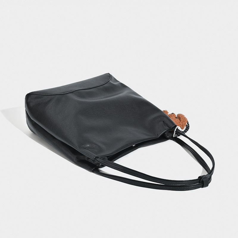 Slouchy leather-look shoulder tote with bear charm tassel in black and coffee brown, detail view 4
