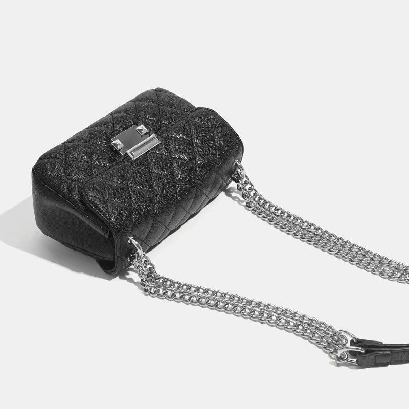 Kleine strukturierte Schultertasche mit Rautensteppung, doppeltem silberfarbenem Kettenriemen und rechteckigem silberfarbenem Verschluss, Detailansicht