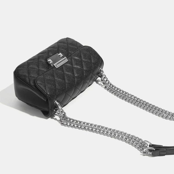 Kleine strukturierte Schultertasche mit Rautensteppung, doppeltem silberfarbenem Kettenriemen und rechteckigem silberfarbenem Verschluss, Detailansicht