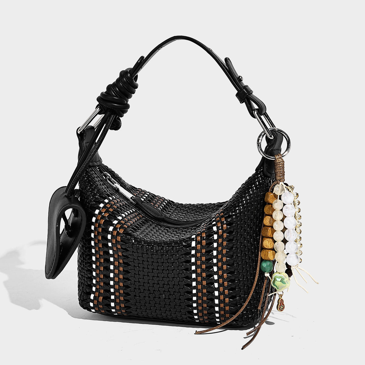 Small woven crescent shoulder bag with leather-look trim, zip closure, silver-tone ring hardware, and beaded tassel charm
