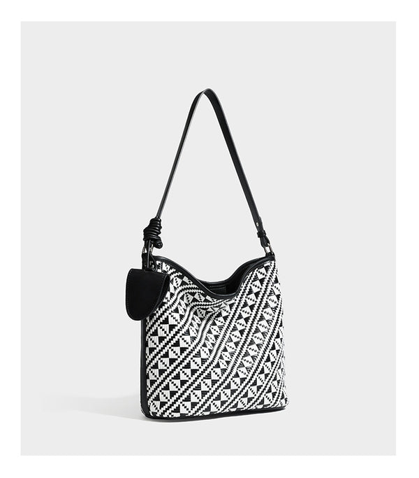 Geflochtene Schultertasche mit geometrischem Ethno-Muster, Besatz in dunkelbrauner Lederoptik, langem verstellbarem Träger und kleinem hängendem Reißverschluss
