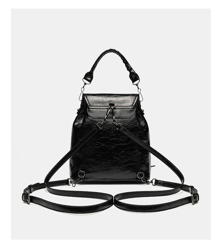 Small structured glossy leather-look convertible backpack handbag in black with flap closure, front zip pockets, metal stud