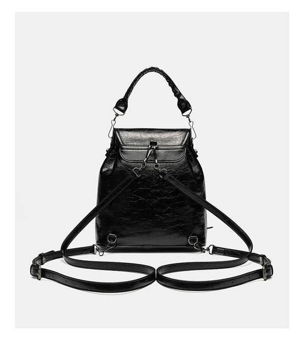 Small structured glossy leather-look convertible backpack handbag in black with flap closure, front zip pockets, metal stud