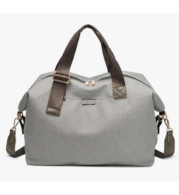 Structured woven duffel bag with dual tan webbing handles, detachable shoulder strap, top zip closure, and gold-tone