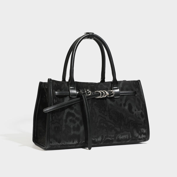 Structured leopard-print tote bag with glossy satin-like finish, dual rounded top handles, silver buckle-and-ring front