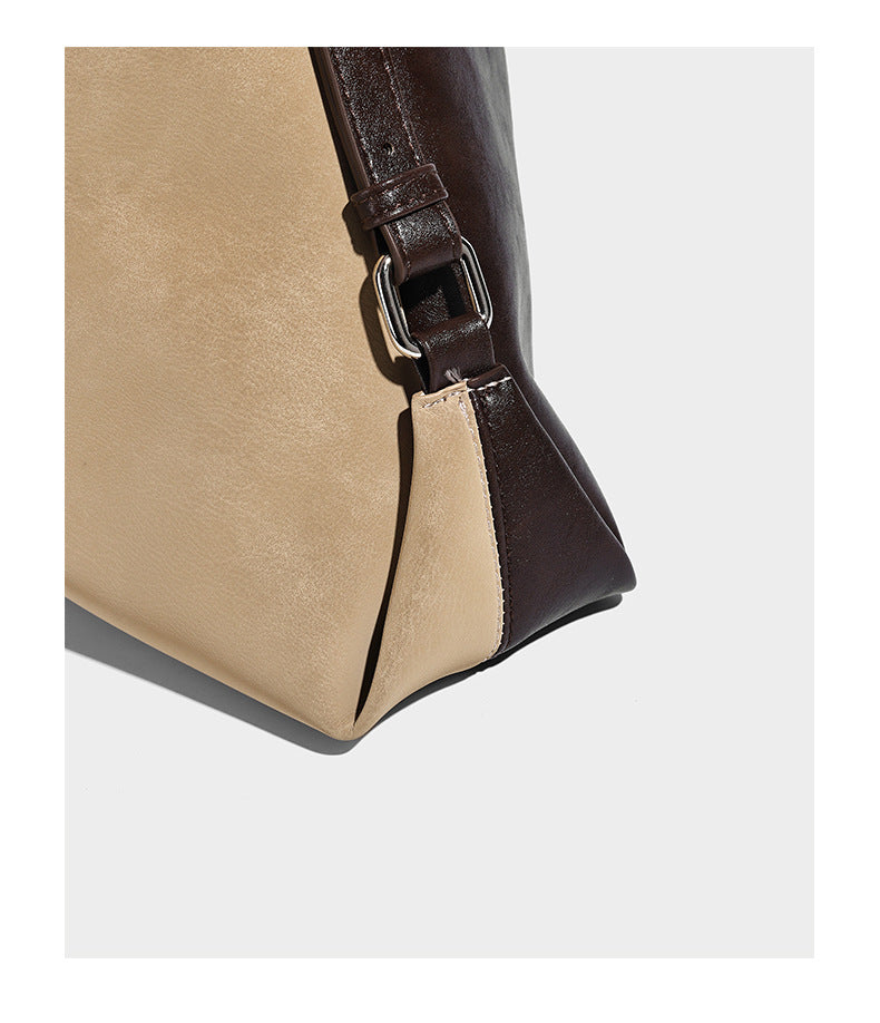 Slouchy hobo tote bag with matte leather-look finish, triangular silhouette, front zip pocket, and adjustable shoulder strap