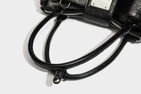 Structured glossy crinkled leather-look satchel with double top handles, front metal-plaque tab, silver-tone hardware, and