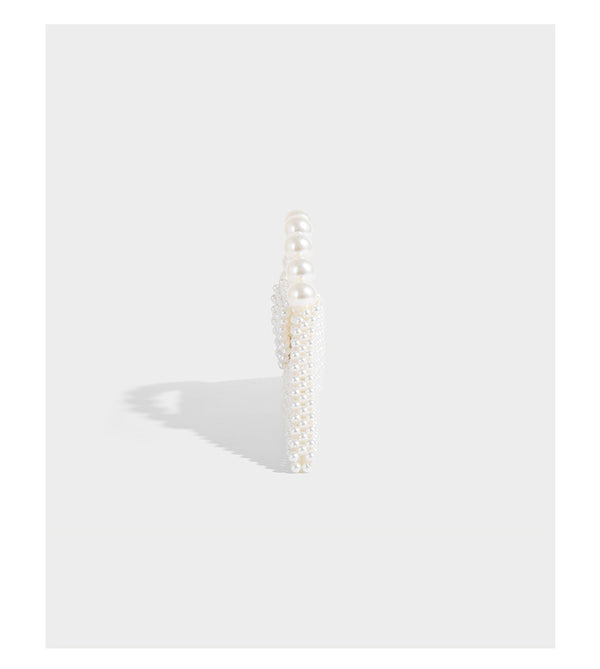 Small structured triangle clutch bag covered in glossy pearl beads with an arched pearl top handle and silver snap closure