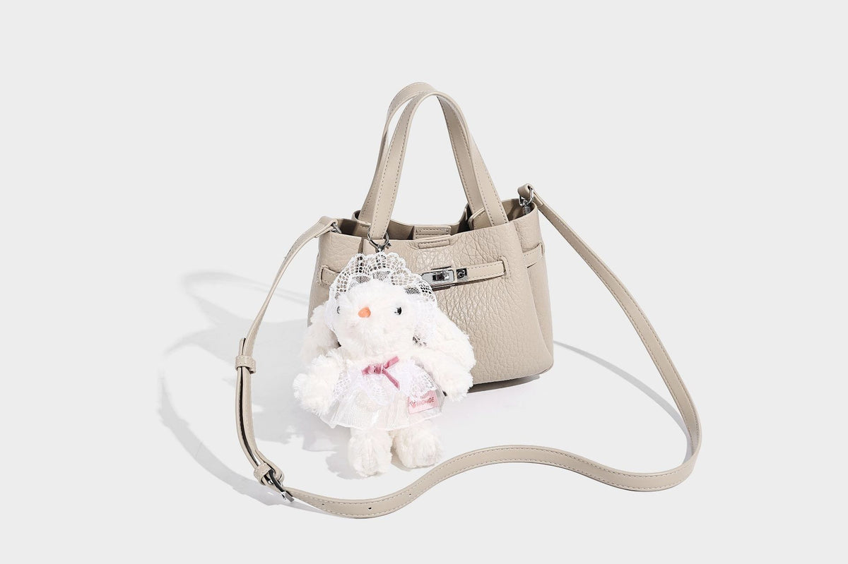 Small structured pebbled bucket tote with double top handles, silver turn-lock hardware, and detachable shoulder strap