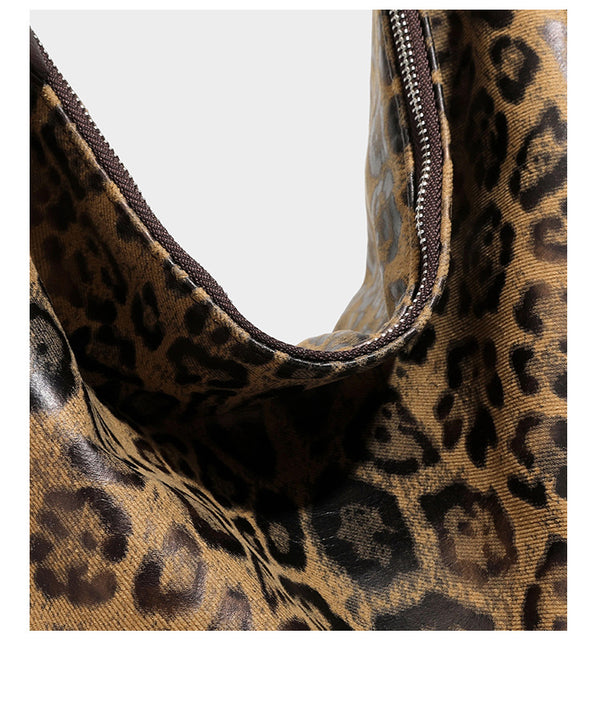 Slouchy leopard print hobo shoulder bag with glossy coated finish, top zipper closure, dark brown trim, and dangling charm