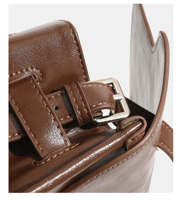 Structured rectangular flap shoulder bag in glossy leather-look finish with silver turn-lock clasp and adjustable strap