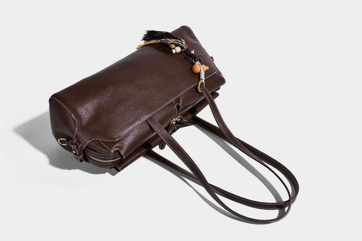 Strukturierte rechteckige Baguette-Schultertasche aus dunkelbraunem Material in glatter Lederoptik mit zwei Riemen und Reißverschluss oben