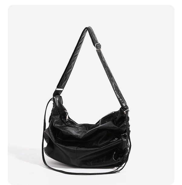 Oversized slouchy hobo shoulder bag with glossy crinkled leather-look finish, drawstring gathered sides, and silver-tone
