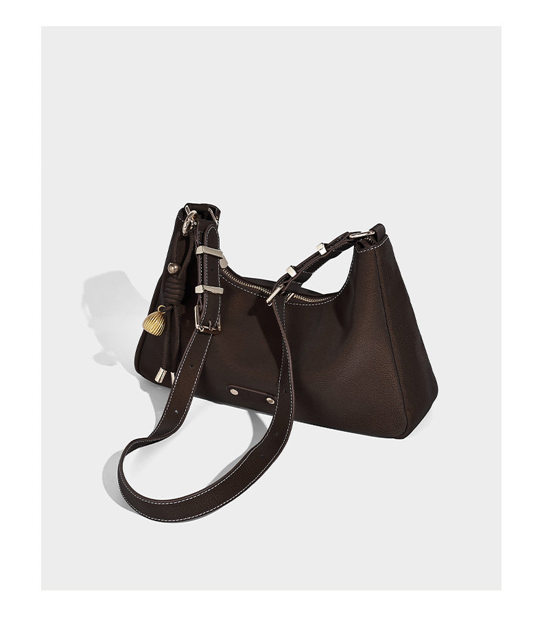 Crescent hobo shoulder bag in pebbled leather-look finish with top zipper, adjustable strap, gold-tone ring hardware, and