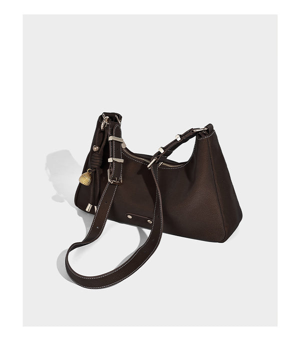 Crescent hobo shoulder bag in pebbled leather-look finish with top zipper, adjustable strap, gold-tone ring hardware, and