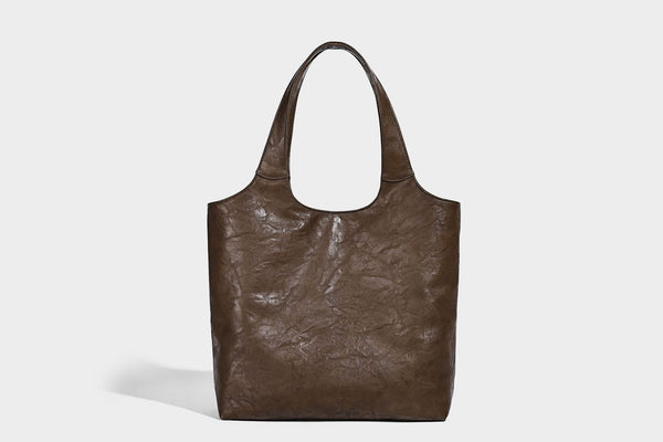 Large open-top tote bag with crinkled leather-look finish, long double shoulder straps, and embossed circular detail on