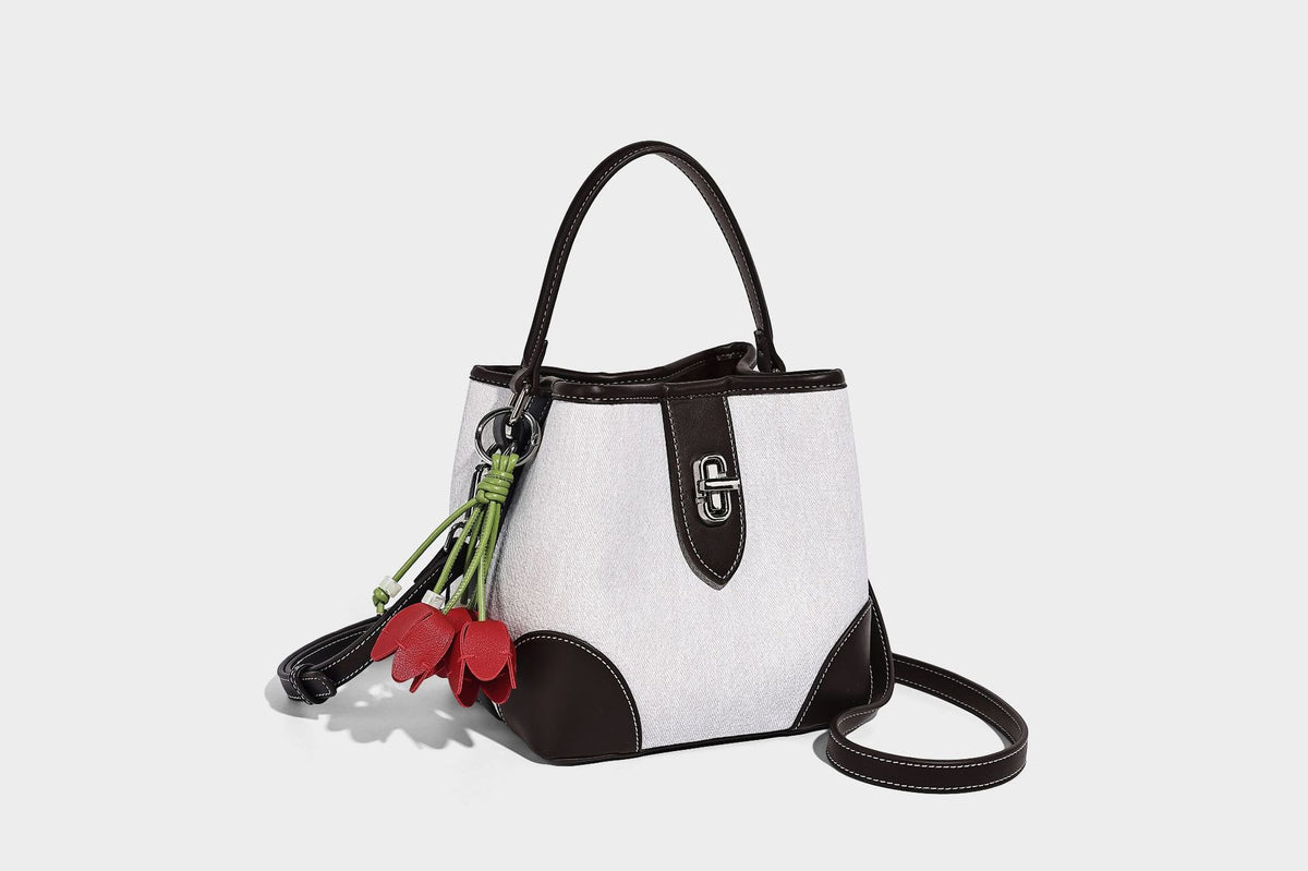 Small structured bucket bag in denim-look light blue fabric with black leather-look trim, silver turn-lock hardware, short