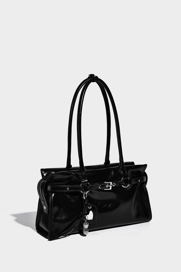 Structured rectangular glossy tote shoulder bag with belt buckle front strap and dangling charm hardware, detail view 9